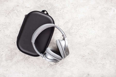 modern silver wireless headphones on concrete background