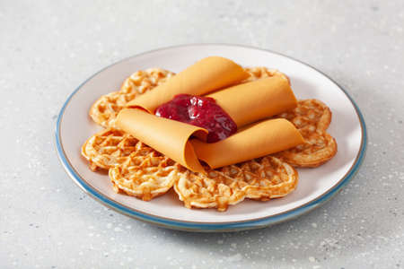 waffles with Norwegian brunost traditional brown cheese and raspberry jamの写真素材