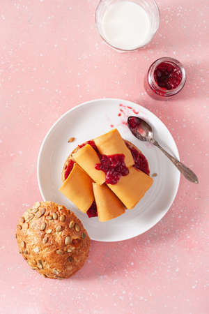 fresh bun with Norwegian brunost traditional brown cheese and jamの写真素材