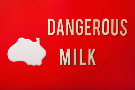 dangerous milk word text letters lactose intolerance allergy. milk splatter. avoid dangerous dairyの写真素材