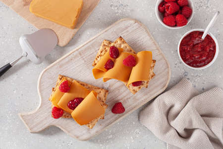 crispbread with Norwegian brunost traditional brown cheese and raspberry jamの写真素材