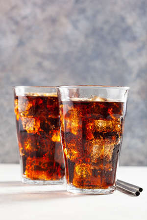 glass of cold cola soft drink with ice on concrete backgroundの写真素材