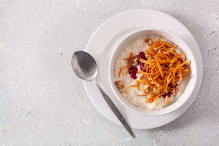 rice pudding with Norwegian brunost traditional brown cheese and raspberry jamの写真素材