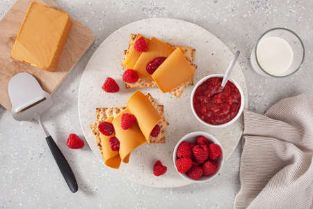 crispbread with Norwegian brunost traditional brown cheese and raspberry jamの写真素材