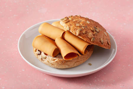 fresh bun with Norwegian brunost traditional brown cheeseの写真素材