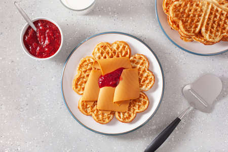 waffles with Norwegian brunost traditional brown cheese and raspberry jamの写真素材