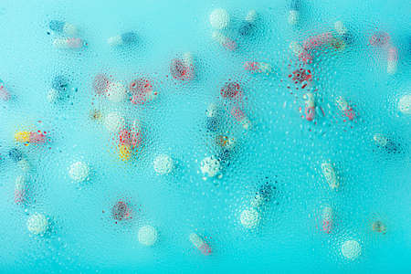 pill tablet capsule medicine through water drops backgroundの写真素材