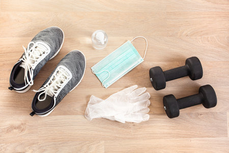 protective medical mask sanitizer gel gloves. fitness training sneakers dumbbell and protective measures against virus, bacteriaの写真素材