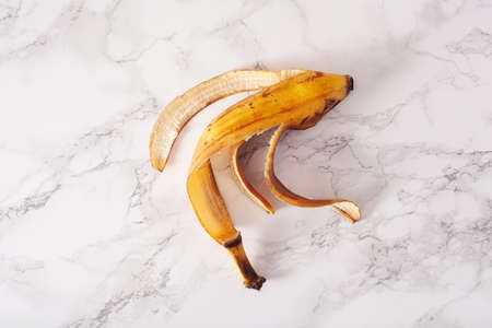 ripe overripe organic banana peel on marble background. ugly food zero waste conceptの写真素材