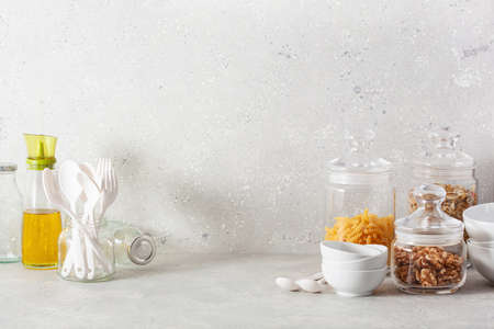 kitchen utensils on modern simple counter, kitchenware jars with dry ingredients bowls