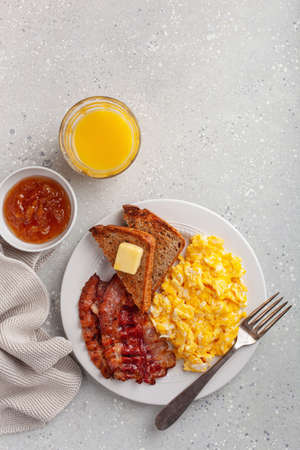 traditional scrambled egg breakfast with bacon and toastの写真素材