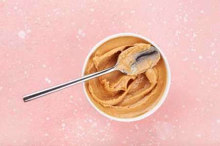 smooth peanut butter in bowl on pink backgroundの写真素材