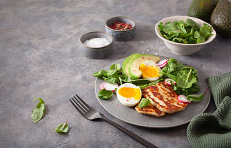 healthy keto paleo diet breakfast: boiled egg, avocado, halloumi cheese, salad leavesの写真素材