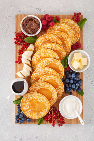 american pancake board with berries maple syrup butterの写真素材