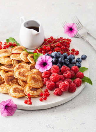 american mini pancake board with berries and maple syrupの写真素材