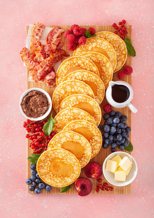 american pancake board with bacon berries maple syrup butterの写真素材