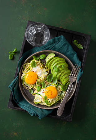 keto low carb breakfast baked spiralized zucchini with eggs and avocadoの写真素材