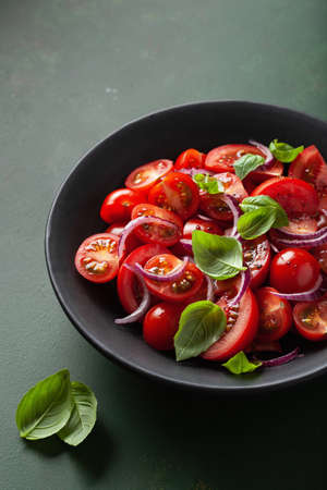healthy tomato salad with onion basil olive oil and balsamic vinegarの写真素材
