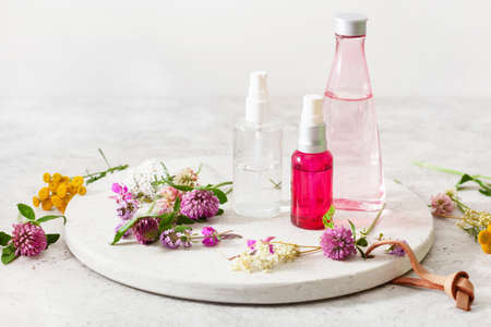 bottles skincare lotion serum medical flowers herbs. natural cosmetic. clover milfoil tansy rosebayの写真素材