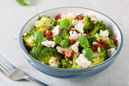 healthy broccoli salad with feta cheese sun dried tomatoes pine nuts.. vegetarian low carb keto dietの写真素材