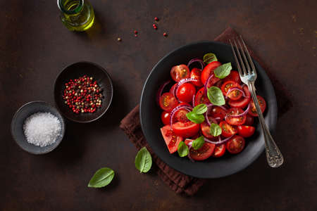 healthy tomato salad with onion basil olive oil and balsamic vinegarの写真素材