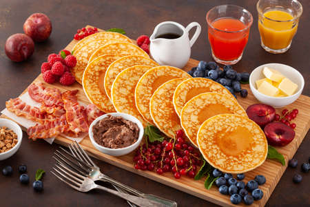 american pancake board with bacon berries maple syrup butterの写真素材
