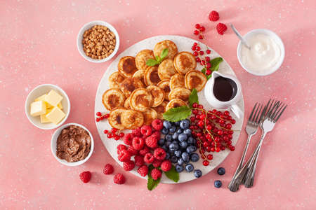 american mini pancake board with berries and maple syrupの写真素材