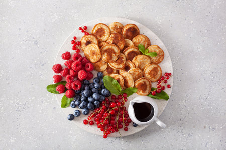 american mini pancake board with berries and maple syrupの写真素材