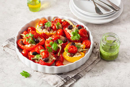 stuffed bell peppers with quinoa tomatoes olives and herb sauce chimichurriの写真素材