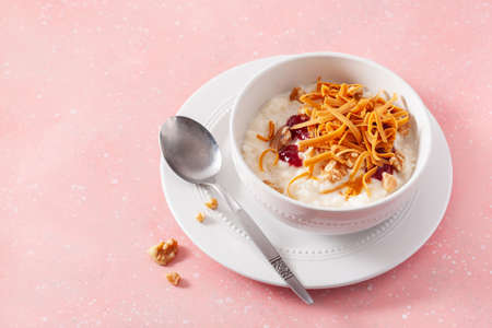 rice pudding with Norwegian brunost traditional brown cheese and raspberry jamの写真素材