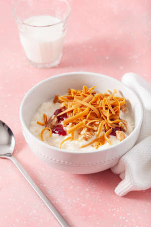 rice pudding with Norwegian brunost traditional brown cheese and raspberry jamの写真素材