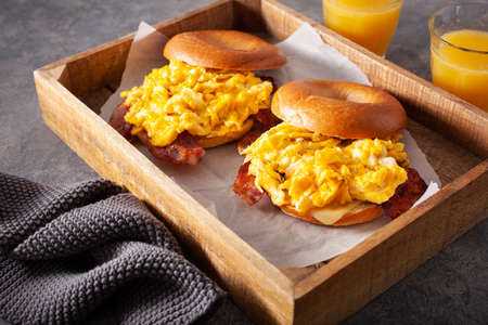breakfast egg and bacon sandwich on bagel with cheeseの写真素材