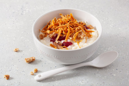 rice pudding with Norwegian brunost traditional brown cheese and raspberry jamの写真素材