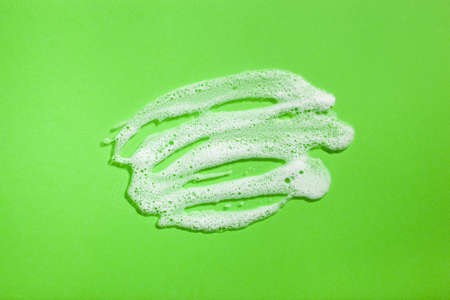 foam soap suds on green background, laundry cleaning washing conceptの写真素材