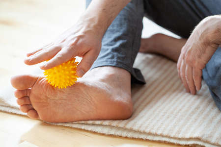man doing flatfoot correction self massage at homeの写真素材