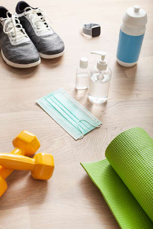 protective medical mask sanitizer gel. fitness training sneakers dumbbell and protective measures against virus, bacteriaの写真素材