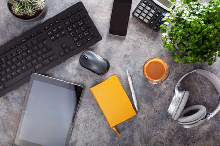 home office desk with keyboard computer smartphone notebook houseplants, workspace at homeの写真素材