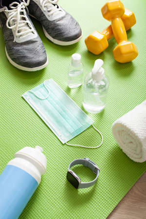 protective medical mask sanitizer gel. fitness training sneakers dumbbell and protective measures against virus, bacteriaの写真素材