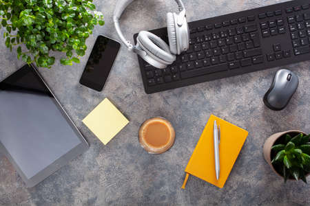 home office desk with keyboard computer smartphone notebook houseplants, workspace at homeの写真素材