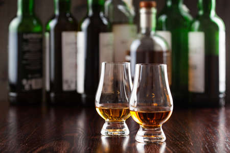 Bottles and glass of whisky spirit brandy on dark brown backgroundの写真素材