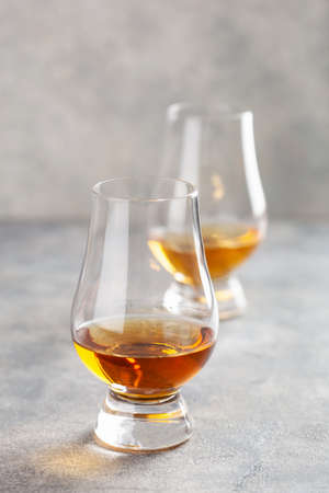 glass of whisky spirit brandy on gray concrete backgroundの写真素材