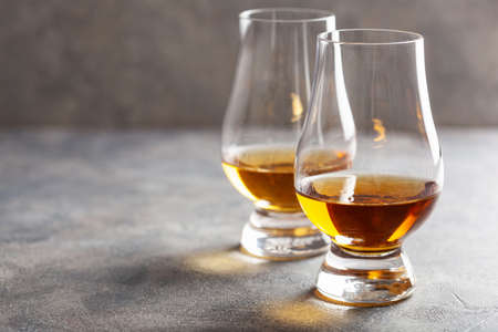 glass of whisky spirit brandy on gray concrete backgroundの写真素材