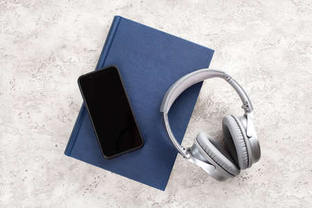 audiobook concept modern wireless headphones smartphone and bookの写真素材