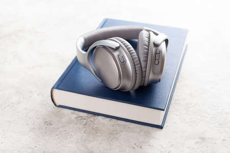 audiobook concept modern wireless headphones and bookの写真素材