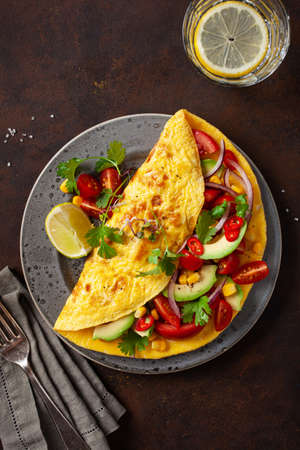 omelette with tomato, avocado onion chili and sweet corn. healthy keto diet low carb breakfastの写真素材