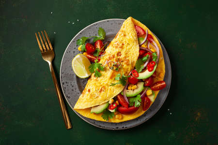 omelette with tomato, avocado onion chili and sweet corn. healthy keto diet low carb breakfastの写真素材