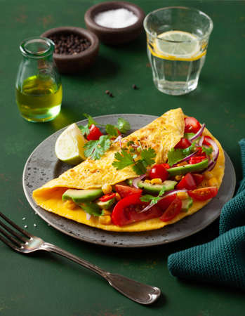 omelette with tomato, avocado onion chili and sweet corn. healthy keto diet low carb breakfastの写真素材