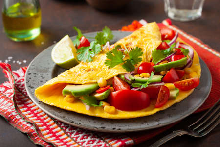 omelette with tomato, avocado onion chili and sweet corn. healthy keto diet low carb breakfastの写真素材