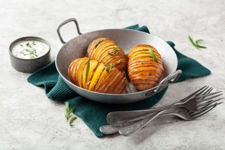 baked hasselback potato with cheddar cheese and rosemary