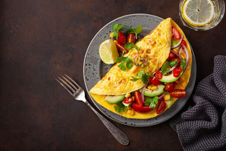 omelette with tomato, avocado onion chili and sweet corn. healthy keto diet low carb breakfastの写真素材